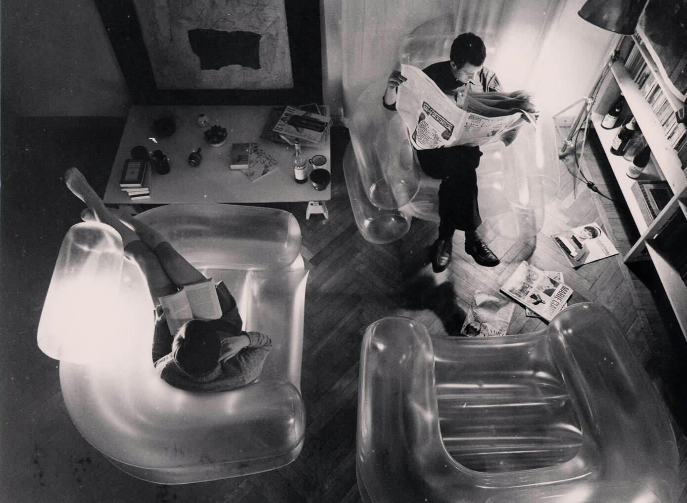 Fotografia d'archivio in bianco e nero che ritrae dall'alto Paolo Lomazzi e Carla Scolari seduti su poltrone gonfiabili Blow intenti a leggere.