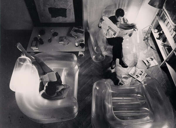 Fotografia d'archivio in bianco e nero che ritrae dall'alto Paolo Lomazzi e Carla Scolari seduti su poltrone gonfiabili Blow intenti a leggere.