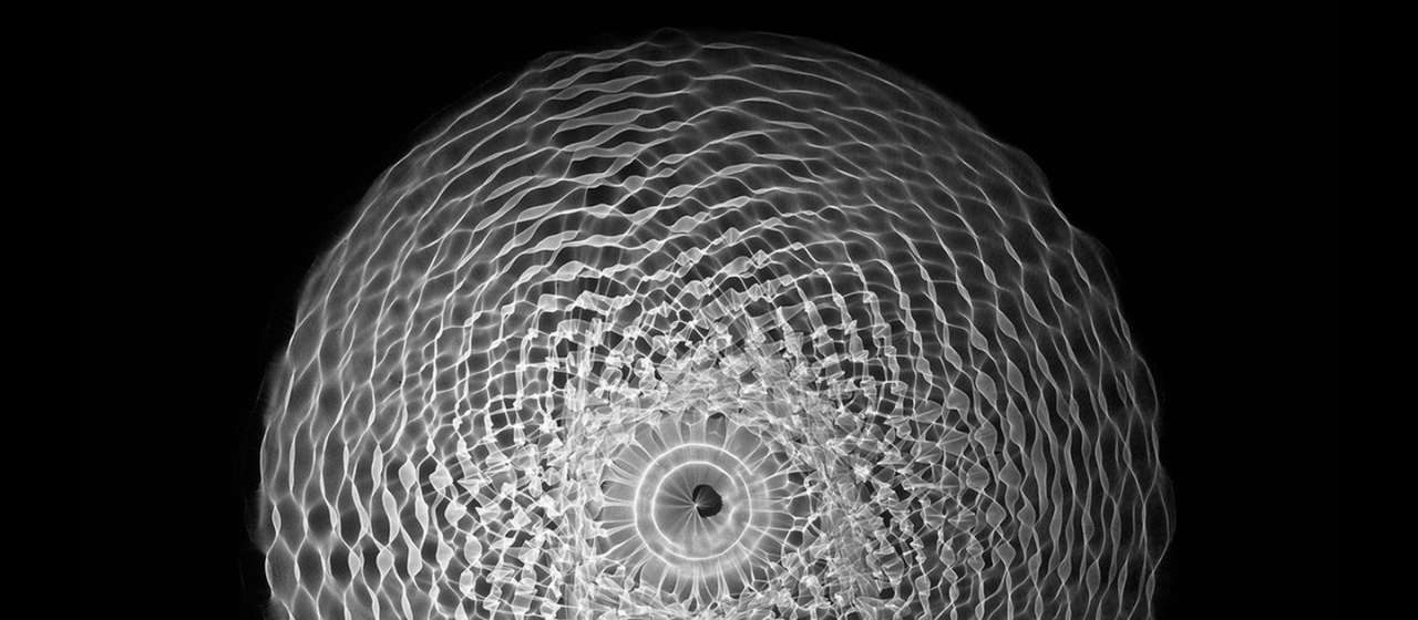 una trama di luce si spande su uno sfondo nero. E' una delle opere precedenti di Pietro Pirelli, l'artista che ha realizzato la Fontana di sole.