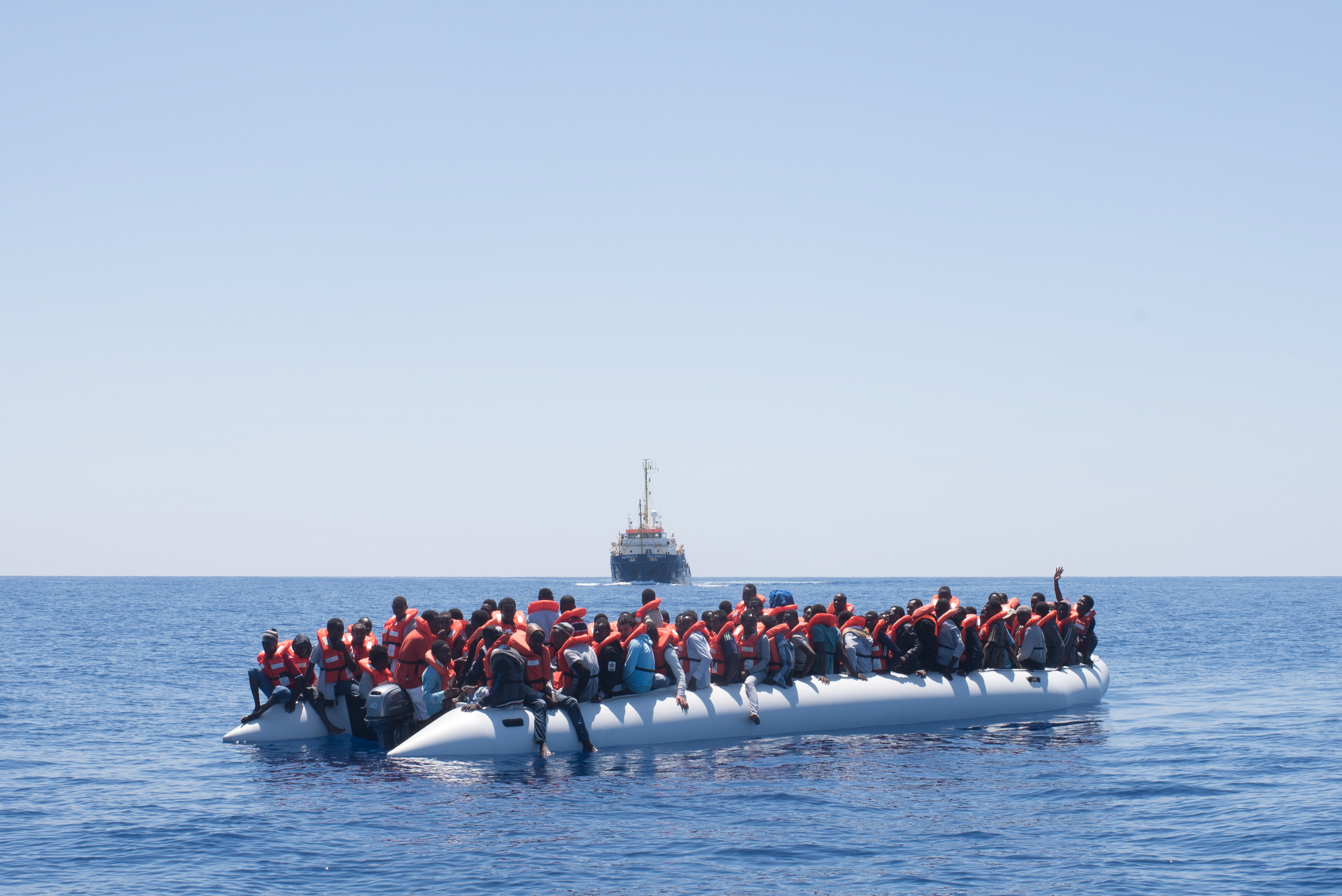 5. 24 Maggio 2018, Decine di persone su un gommone e sullo sfondo la Sea-Watch 3, credit: Chris Grodotzki / Sea-Watch